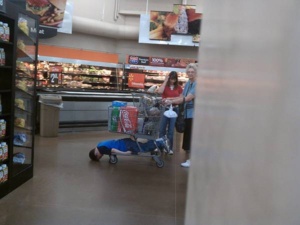 criança cansada no carrinho do supermercado