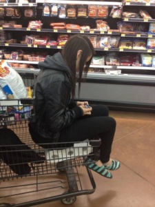 jovem sentada no papel higiênico no carrinho de supermercado